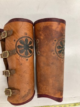 Unisex, Historical Fiction Greaves, MTO, Lt Brown, Faded Black, Leather, Metallic/Metal, Solid, Floral, Textured, Aged, 4 Brass Buckle Closures. 16" Wide At Top Of Calf. 2 Embossed Medallions, Dark Red Leather Trim At Top And Bottom. PAIR. MULTIPLE