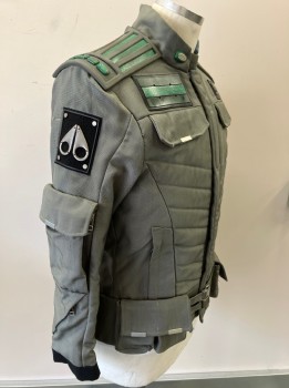 MTO, Gray, Green, Black, Nylon, Synthetic, Quilted Front, Zip/snap Front, Stand Collar, 2 Zip Pkts., Utility Pouch Pockets with Flaps - 2 In Front & 2 On Back, 2 Flaps On Chest (faux Pkts), 2 Self Belt Tabs At Front Waist, Zipper Pkts & Flap Pkts On Sleeves, Green & Gray Rubber Back Yoke, Black with Silver Metal Appliquéd Patches On Slvs,