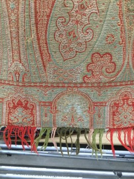 NL, Red, Green, Wool, Paisley/Swirls, Square Paisley Woven Shawl in Muted Reds and Greens, Self Fringe on Two Sides. Repairs Done in Center of Shawl. Also Hole in Center of Shawl, in Fragile State,
