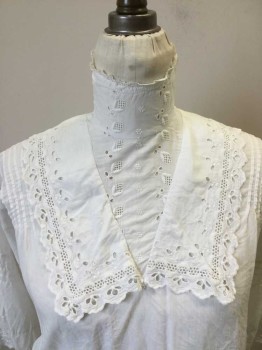 N./L, White, Cotton, Solid, Floral, Cotton Broadcloth Blouse with Eyelit Yoke with Sailor Like Collar & High Collar Band. Button Closure Center Back, Tuck Pleats at Shoulders Front and Back. Tuck Pleats at Mid Sleeve. Twill Tape at Waist Back. 3/4 Sleeves with Eyelit Lace Trim at Cuffs,
