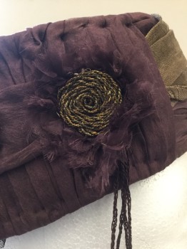 NL, Plum Purple, Gold, Silk, Metallic/Metal, Solid, Turban in Muted Plum Silk with Sheer Metallic Gold Drape at Flat Crown and Side Left With Double Rosette  in Self Silk with Raw Edging and Gold Metallic Braid in Center. Self Trimmed with Silk Tuffts,